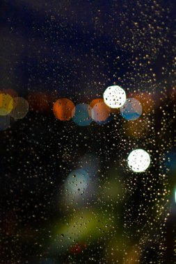 Pencerelere su damlaları ve günbatımında şehir batımları.