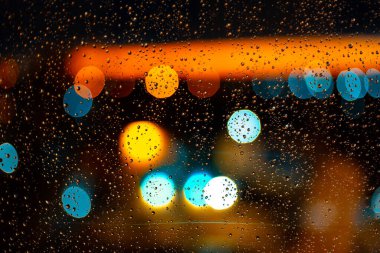 Pencerelere su damlaları ve günbatımında şehir batımları.