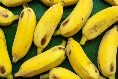 Yeşil muz yaprağının üzerinde sarı muz deseni vardı. Çevre yiyecekleri.