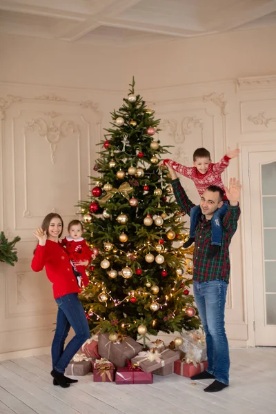 Happy family decorate the Christmas tree indoors together. Loving family. Merry Christmas and Happy Holidays.
