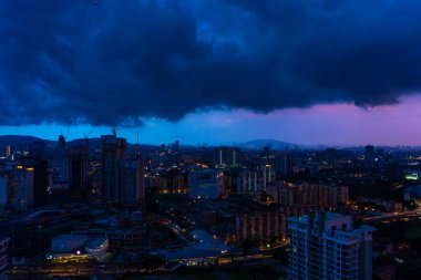 Yağmur bulutlarıyla akşam şehir batımı. Gece yağmuru. Kuala Lumpur 'un muhteşem manzaraları.