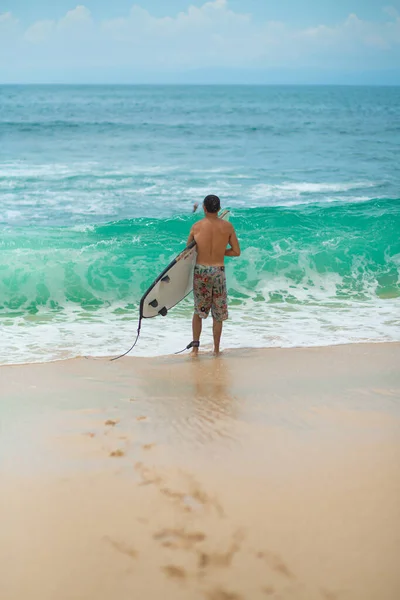 サーファーだ サーフボードでサーフィン男サンディ トロピカル ビーチを歩く 健康的なライフスタイル 水の活動 ウォータースポーツ 美しい海 — ストック写真
