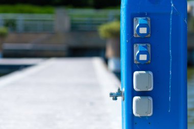 Elektrik prizli servis direği ve yat rıhtımında içme suyu olan musluk..