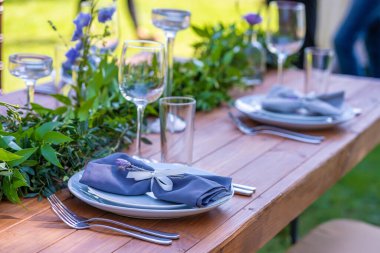 Açık hava kafede güzel dekore edilmiş ahşap bir masa. Yeşil dal ve taze çiçek masa dekorasyonu.