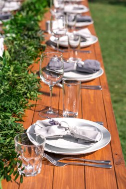 Açık hava kafede güzel dekore edilmiş ahşap bir masa. Yeşil dal ve taze çiçek masa dekorasyonu.