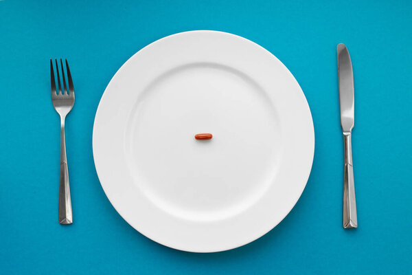 Маленькая табличка в тарелке. Медицинская концепция. Ешьте таблетки вместо еды