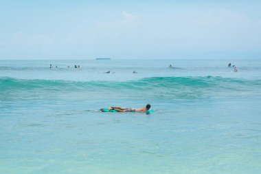 Adam okyanusta sörf tahtasında yüzüyor. Yaz mesleğinde sağlıklı aktif yaşam tarzı