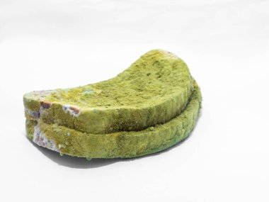 Beyaz arka planda yeşil küfle kaplı bir parça ekmek izole edilmiş..