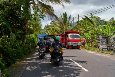Bali adasında asfalt yollar, arabalar ve motosikletler. Asya köylerinde rahat bir yol. Bali, Endonezya - 08.12.2022