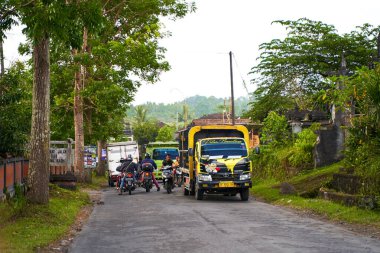 Bali adasında asfalt yollar, arabalar ve motosikletler. Asya köylerinde rahat bir yol. Bali, Endonezya - 09.12.2022