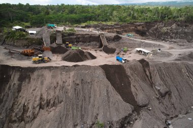 Endonezya 'da taş ocağı. Bölgede buldozerler ve çöp kamyonları gibi büyük ekipmanlar çalışıyor
