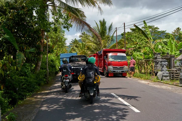 Bali adasında asfalt yollar, arabalar ve motosikletler. Asya köylerinde rahat bir yol. Bali, Endonezya - 08.12.2022