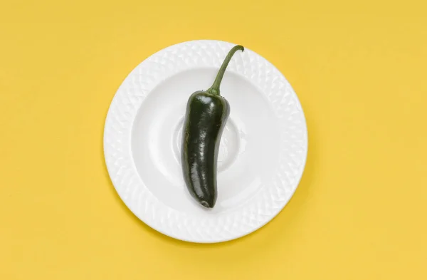 Single Green jalapeno peppar på plattan på gul bakgrund — Stockfoto