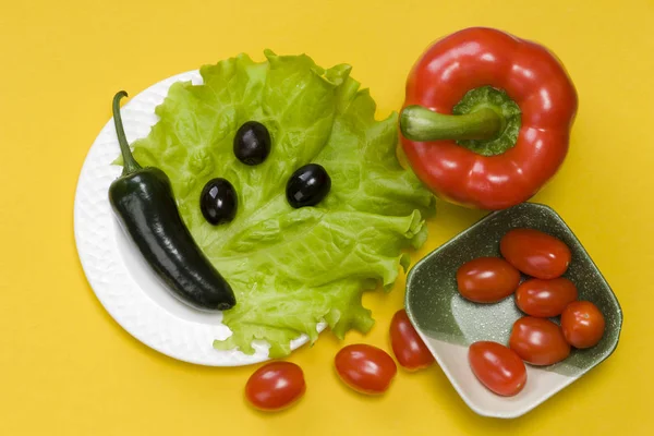 Stillleben von Jalapeño-Paprika, Paprika, Tomatenkirsche, Salat auf gelbem Hintergrund — Stockfoto