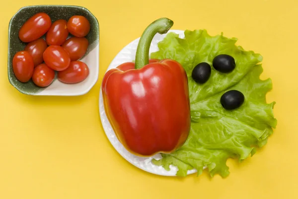 Martwa żywotność papryki, wiśni pomidorowej, sałaty i oliwek na żółtym tle — Zdjęcie stockowe