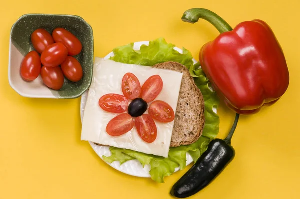 Szendvics zöldségekkel fehér tányéron sárga alapon — Stock Fotó