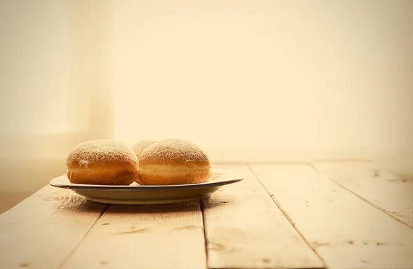 Still life for jewish holiday Hanukkah with Donuts on the Plate, Rustic wooden table with Window backlight.Shallow DOF.Shallow DOF.Hanukkah celebration concept.