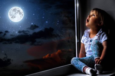 çocuğun pencerenin gece gökyüzüne dışında görünüyor