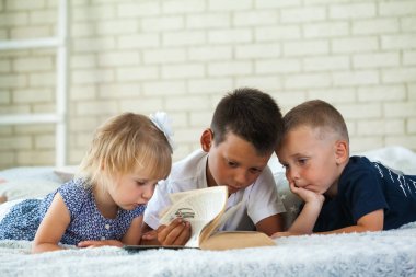 Çocuk yatağın üzerine bir kitap okumak