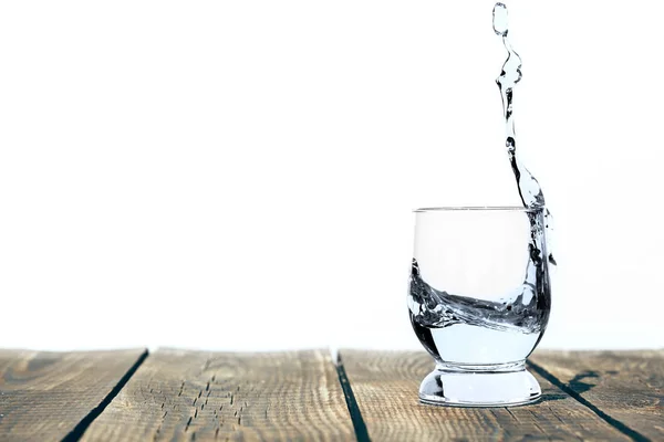 A water in a glass on a wooden floor — Stock Photo, Image