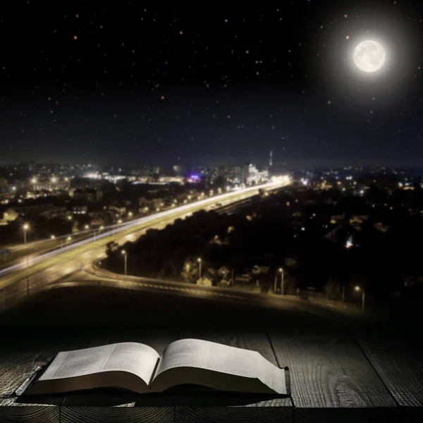 Livre contre une ville nocturne clair de lune — Photo