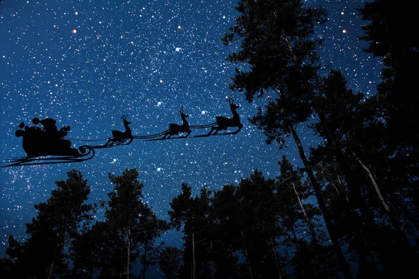 Silueta de un gótico volador santa claus sobre el fondo del cielo nocturno. —  Fotos de Stock