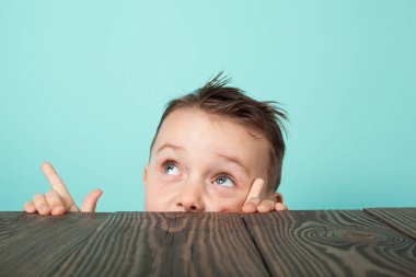  çocuk masanın altından dışarı sürünerek ve yukarı bakar