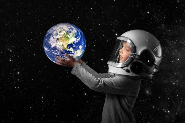 Egy kisgyerek űrhajósnak képzeli magát egy űrhajós sisakjában.. — Stock Fotó