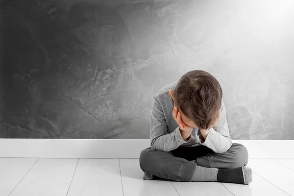 Un niño cuya depresión está sentado en el suelo — Foto de Stock