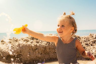 deniz kıyısında oynayan bir çocuk