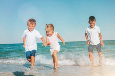 dalgalar ile deniz kıyısında çalışan bir çocuk