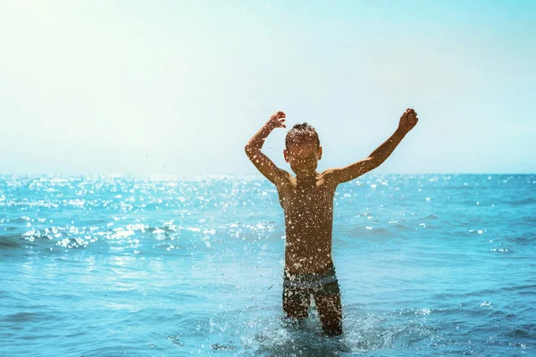 Un enfant courant au bord de la mer avec des vagues — Photo