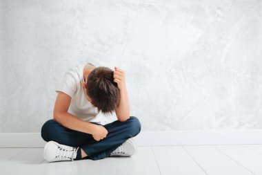 a child whose depression is sitting on the floor clipart