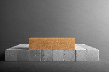 Gri arka planda parmakları tutan bloklara kazınmış iş yazıları. 