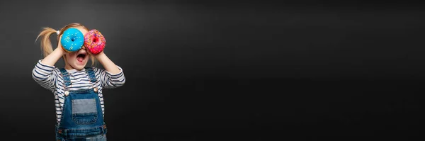Счастливая Симпатичная Девушка Весело Играет Донатом Черном Фоне Стены Яркое — стоковое фото