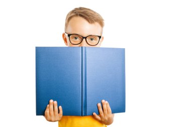 Çocuk parlak bir duvara karşı kitap okuyor.