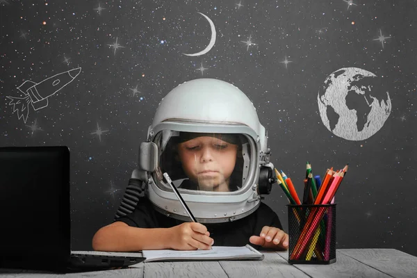 the child studies remotely at school, wearing an astronaut\'s helmet. back to school