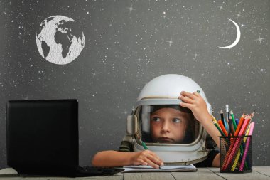 Çocuk, astronot kaskı takarak okulda uzaktan çalışıyor. Okula dönüyorum. efekt hatası