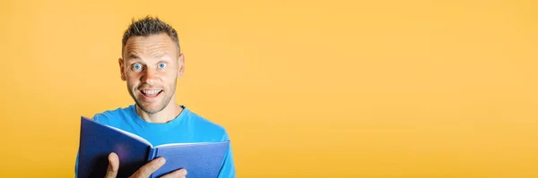 man reads a book against a bright wall