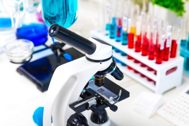Geliştirme, tıp, eczacılık, biyoloji, biyokimya ve araştırma teknoloji kavramı yaratıcı soyut kimya: bilimsel kimyasal Laboratuvar Cihazları - mikroskop, test tüpleri ile renk sıvı madde örnekleri, şişeleri, şişeler, dosya içeren tablo