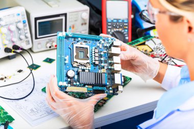 Genç kadın dijital elektronik mühendisi bilgisayar Pc anakart laboratuvarında incelenmesi
