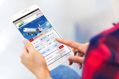Yaratıcı iş seyahat, turizm ve kablosuz internet web iletişim teknoloji kavramı: makro görünümü genç kadının hava satın bilet online seçici odak etkisi ile tablet bilgisayarda