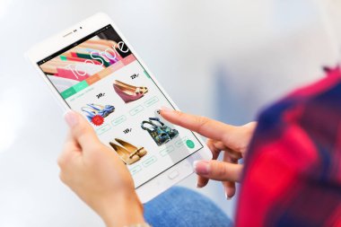 Tablet bilgisayarınızla alışveriş online ve satın alma ve seçici odak etkisi ile ödeme yapma genç kadın