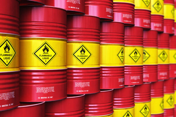 Creative abstract oil and gas industry manufacturing and trading business concept: 3D render illustration of the group of the industrial storage warehouse with a stacked rows of red metal oil drums or petroleum barrels with selective focus effect