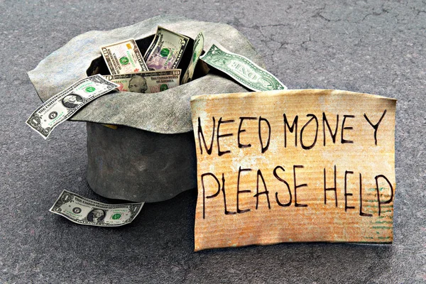 宏观视图的无家可归的穷人乞丐的帽子与美元货币现金钞票和帮助信息对一块纸板在街道沥青户外 — 图库照片