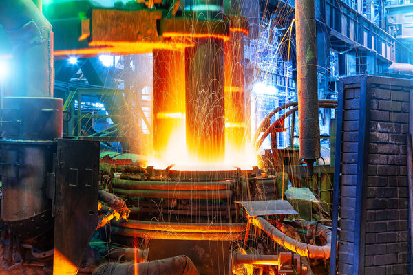 Рабочая электродуговая печь в цехе металлургического завода
