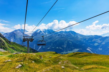 Yeşil çimenli tepe dağ dağlık karlı zirveleri ve teleferik Asansör destekler İsviçre Alpleri'nde görünümünü doğal yaz