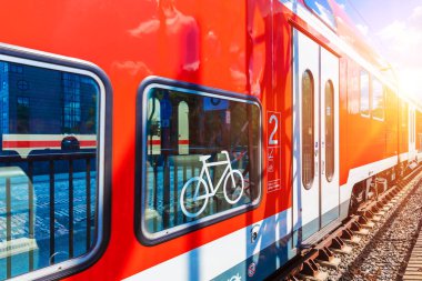 Yaratıcı soyut demiryolu seyahat ve demiryolu ulaşım sanayi kavramı: modern kırmızı yüksek hızlı elektrikli yolcu banliyö çift güverte tren ile bisiklet simge veya işareti istasyonu platformu