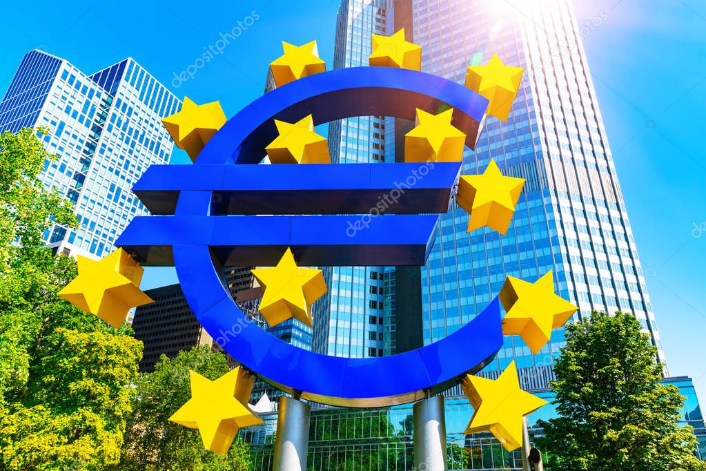 Scenic summer view of the Euro money symbol in business corporate downtown financial bank district with high modern tall glass skyscraper buildings in the park against blue sky Frankfurt am Main, Germany