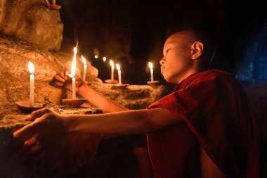 Bagan, Myanmar - Desember 8: eski pagoda tapınakta mandalay Tarih Parkı içinde mumlar ile dua küçük Budist rahip. Desember 8, 2016, Myanmar